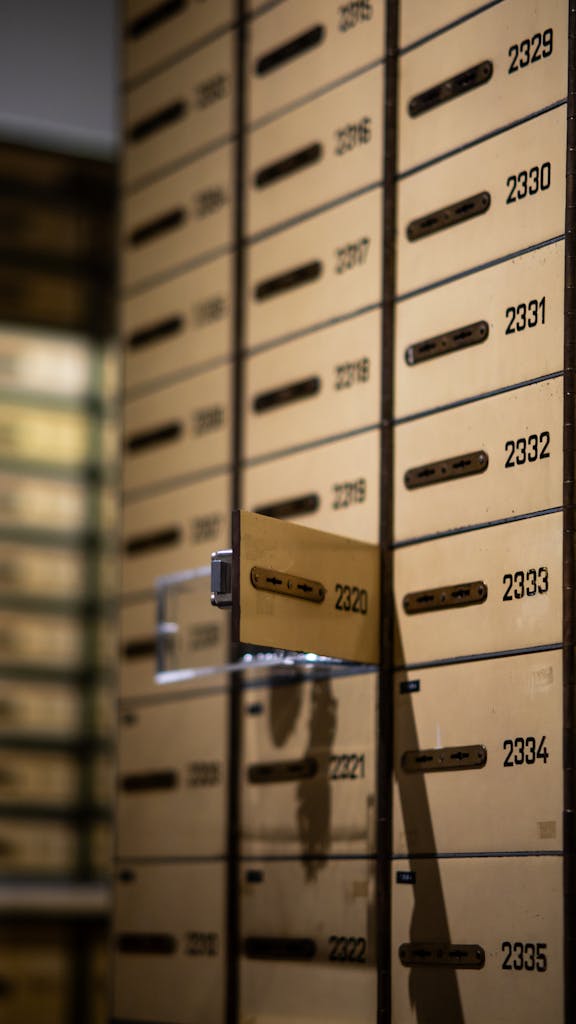 Vertical shot of metallic lockboxes with numbers in a bank vault.